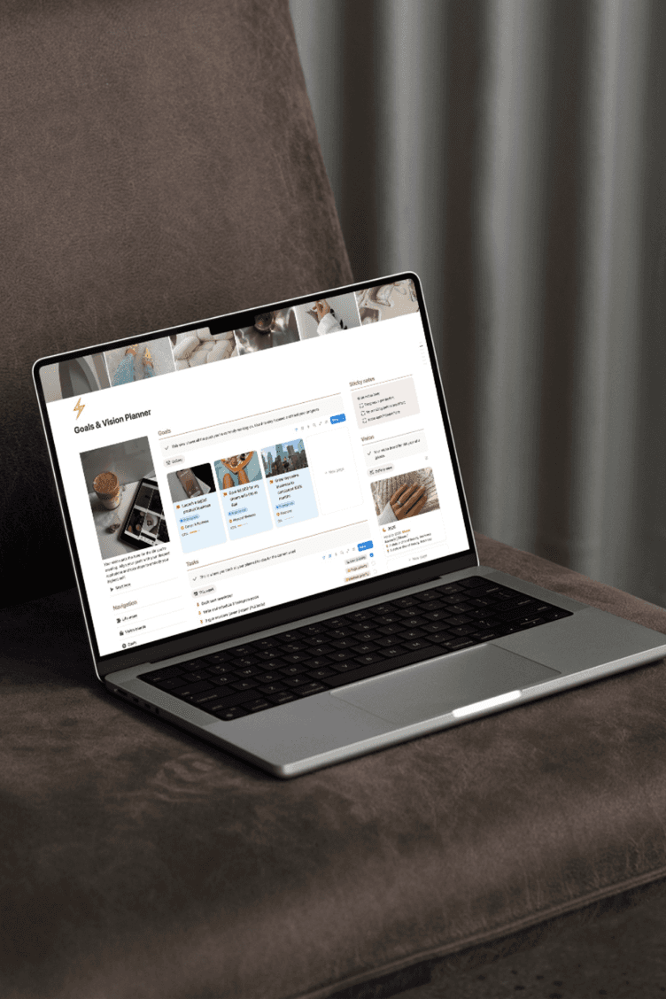 A laptop on a couch showing the Goals & Vision Planner open in Notion